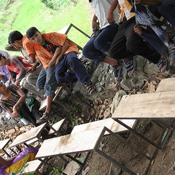 Volunteers carrying new desks finally reach Bhairabi
